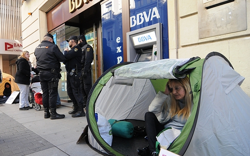 Demasiado tarde: con la gente mirando, ya solo queda "proteger" la entrada del banco.